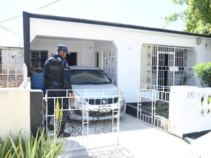 A policeman at a home in Breaton, Portmore, St Catherine where a woman was killed and her daughter injured in an attack on February 17.