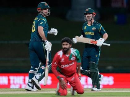 Australia’s Travis Head and captain Mitchell Marsh run between the wickets as Oman’s Jay Odedra (centre) dives to field a ball during the T20 World Cup cricket match between Australia and Oman in Pallekele, Sri Lanka, yesterday.