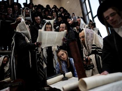 Jewish ultra-Orthodox men and children, some wearing costumes read the Book of Esther, which tells the story of the Jewish festival of Purim, at a synagogue in Bnei Brak, Israel, Friday, March 14, 2025. 