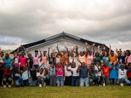 UNICEF Jamaica 
Children, facilitators, and community members gather outside a UNICEF-supported temporary learning space. 