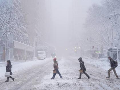 Pedestrians cross 42nd Street near Bryant Park during a snow storm, Monday, February 23, 2026, in New York. (AP Photo/Seth Wenig)