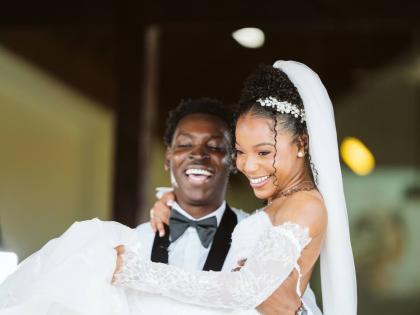 Beaming with joy, Dalkeith lifts his bride, Rohanna, as they exit the Constant Spring Church of Christ in St Andrew.