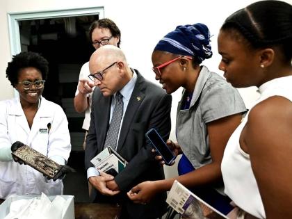 Members of the US Embassy team (3rd left – right), Public Affairs Attaché Mike Lavallee, Resource Coordinator, Kimberly-Joe Osborne and Resource Coordination Assistant, Monique Lindsay-Armstrong, look at a 17th-century Port Royal artefact displayed by K
