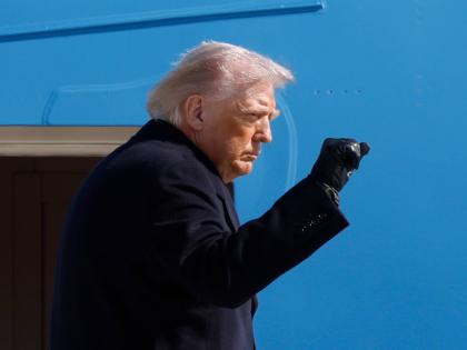 President Donald Trump gestures from the stairs of Air Force One upon his arrival at Joint Base Andrews, Md., Friday, February 27, 2025. (AP Photo/Luis M. Alvarez)
