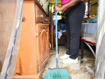
Aneita Williams cleaning mud from her house in The Estuary, a housing development in Friendship, St James, after the passage of Hurricane Melissa last October. Now displaced and given temporary accommodation by the NHT, she does not wish to return to her 
