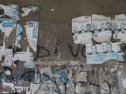 Old campaign posters from the 2016 presidential election cover a wall along a sidewalk in Port-au-Prince, Haiti, Monday, March 2, 2026. (AP Photo/Odelyn Joseph)