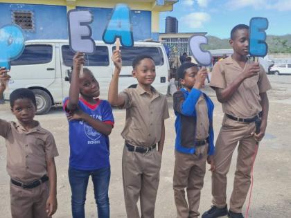 Students of Beaufort Primary School hold up letters spelling the word ‘PEACE’ while performing an item during the school’s Peace Day devotion in Darliston, Westmoreland, yesterday. 