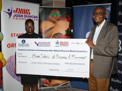 Dr David McBean, executive director of the Mona School of Business and Management (right), and Deidre-Ann Burrell, Programme Officer at the Development Bank of Jamaica, mark DBJ’s $3 million commitment to the Vincent HoSang UWI Venture Competition, a par