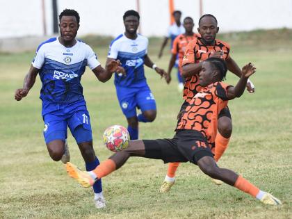 Mount Pleasant’s Football Academy’s Jashaun Angli (left) tries to evade the sliding challenge of Tivoli Garden’s Denville Watson during their rescheduled Jamaica Premier League game at the Edward Seaga Sports Complex yesterday. Anglin scored in the 1