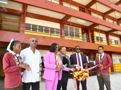 Education Officer for Region 5, Ministry of Education, Skills, Youth and Information,  Marsha Fennell-Bell (third left), cuts the ribbon to officially hand over the new 11-classroom block at Holmwood Technical High School in Manchester on Monday. Sharing i
