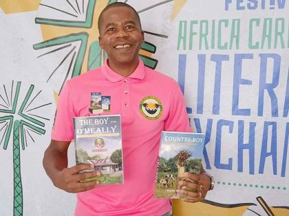 Everton G. Walker displaying his autobiographies, ‘Country Boy - The Omeally Memoirs’ and ‘The Boy from Omeally’.

