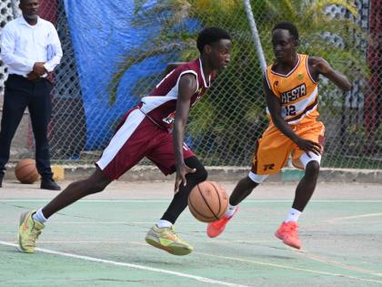 Herbert Morrison Technical High’s Michael Johnson (left) dribbles past Manchester High’s Waine Green Jr during game one of their ISSA Rural Schoolboy Under-16 Basketball finals at Herbert Morrison’s court on Monday, March 2.