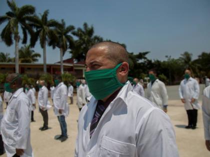 In this 2020 photo doctors form up during a farewell ceremony as they get ready to leave for Italy to help with the new coronavirus pandemic, in Havana, Cuba.