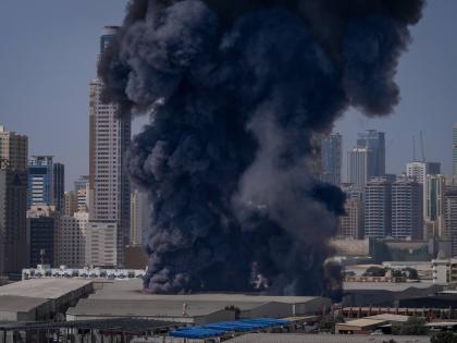 A black plume of smoke rises from a warehouse in the industrial area of Sharjah City following reports of Iranian strikes in Dubai, United Arab Emirates.