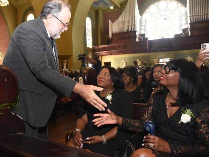 Opposition Leader Mark Golding pays his respects to Sly Dunbar’s daughter, Natasha (centre) and wife, Thelma.
