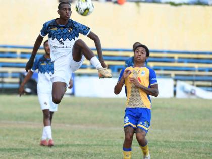 Giovanni Cunningham of Racing United FC controls the ball in the air as Geo Headley of Harbour View FC looks on during a Jamaica Premier League football match at the Harbour View Stadium in Kingston yesterday. Racing won 3-0. 