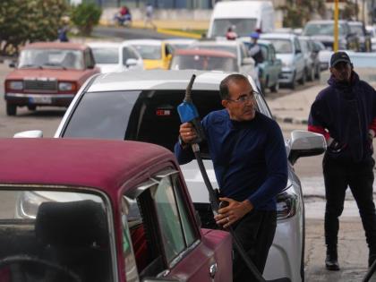 A driver refuels others wait in a long line behind to fill up at a gas station in Havana, Cuba, Tuesday, January 27, 2026. (AP Photo/Ramon Espinosa)