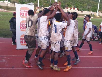 Jamaica College’s under-16 team celebrates with the Burger King Under-16 football trophy after a 2-1 win over Kingston College at Stadium East yesterday.