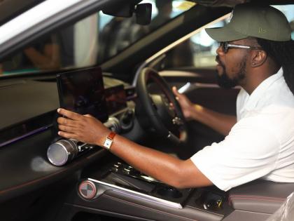 Jamaican influencer Pedro gets a hands-on experience with the advanced infotainment system of a new GAC GS3 Emzoom during the recent launch event. 