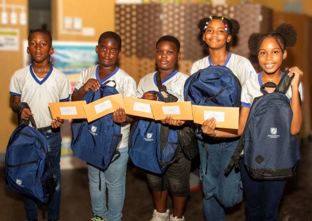 From left: Nathan Williams, Ronaldo O’Connor, Keneik Reid, Najae Biggs and Alana Pottinger from Old Harbour Bay Primary School, show off their backpacks and financial aid vouchers as they were more than 1,000 beneficiaries of Excelerate Energy’s Back-t
