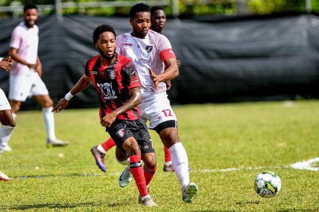 Jamone Anthony (left) of Arnett Gardens and Andrew Vanzie of Chapelton Maroons battle for possession during their Jamaica Premier League football match at Turner’s Oval in Chapelton, Clarendon, yesterday. Arnett won 1-0.