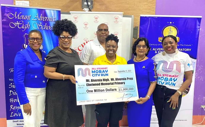 Principal of Mount Alvernia High, Kayon Whyne (second left) and Centennial Committee Chairman Marline Stephenson Dalley (left), accept a symbolic $1-million cheque from the Jill Stewart MoBay City Run in support of centennial projects at Mount Alvernia Hig