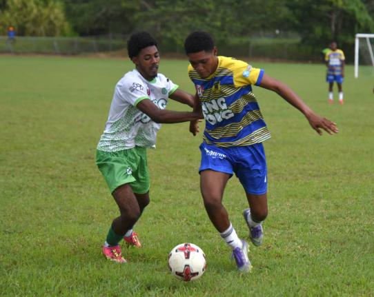 Rusea’s High School’s Maliek Headed (right) tries to shake the attention of Frome Technical High Schol’s Jevani Plummer during their Zone B match of an ISSA daCosta Cup at the Collin Miller Sports Complex. Lightning ended the contest at halfime with 