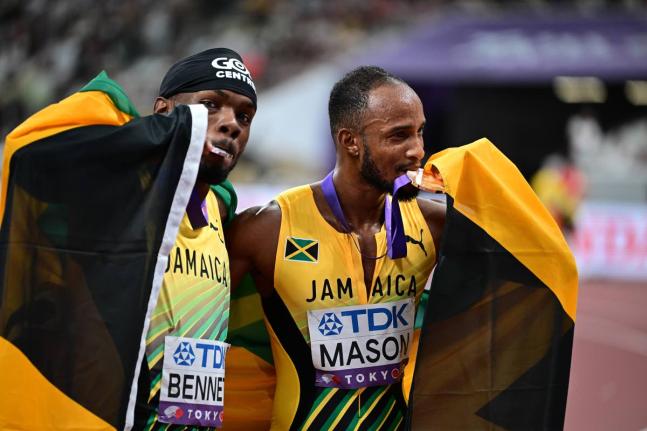 Tyler Mason (right) and Orlando Bennett celebrate the respective bronze and silver medals they earned from the men’s 110-metre final at the World Athletics Championships inside the Japan National Stadium yesterday in Tokyo. 
