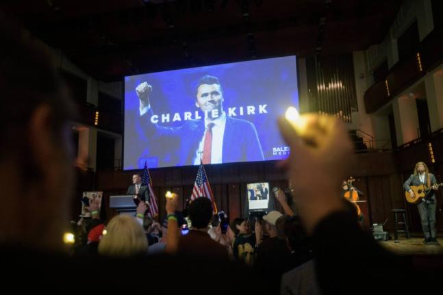 People hold candles and sing during a memorial and prayer vigil for Charlie Kirk at the John F. Kennedy Memorial Center for the Performing Arts in Washington DC. 