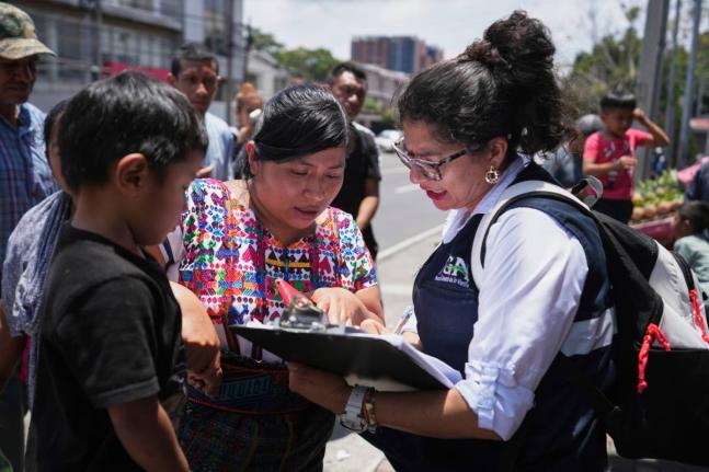 A relative of an unaccompanied minor deported from the United States reviews the list of those deported outside La Aurora International Airport, in Guatemala City on August 31.