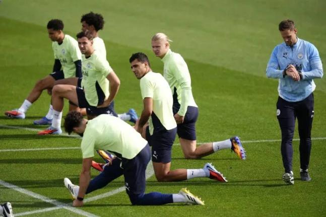 Manchester City’s Rodri and Erling Haaland (both centre, facing)  with team-mates during a training session at the City Football Academy, Manchester, England, on Wednesday, September 17, ahead of their Champions League soccer match against Napoli. 