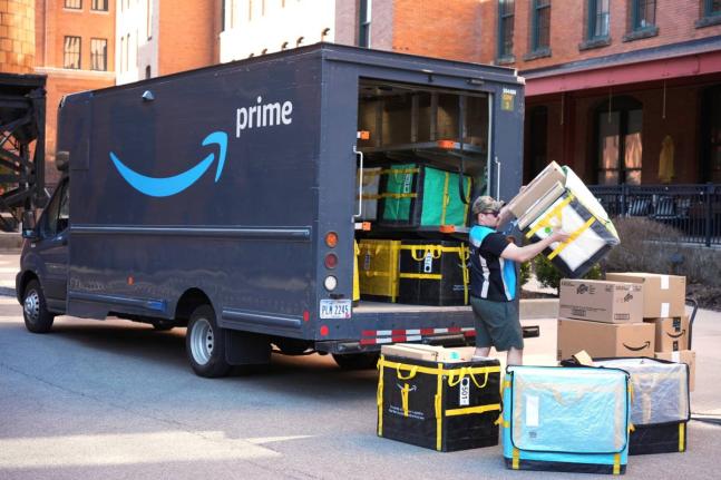 An Amazon Prime driver makes a delivery outside an apartment building in Pittsburgh, March 10, 2025.
