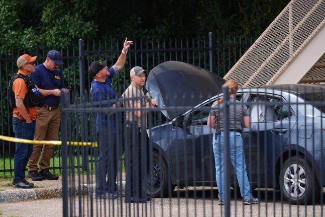 A law enforcement agents search a vehicle near the scene of a shooting at a US Immigration and Customs Enforcement office in Dallas on Wednesday, September 24, 2025. (AP Photo/Julio Cortez)