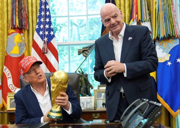 President Donald Trump holds the FIFA World Cup Winners Trophy as FIFA President Gianni Infantino looks on during an announcement in the Oval Office of the White House, August 22, 2025, in Washington. (AP Photo/Jacquelyn Martin, File)