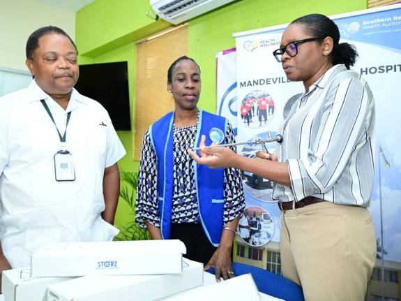 Urology Consultant at the Mandeville Regional Hospital, Dr Davon Mitchell (right), explains the function of a urology instrument, during the handover of pieces of equipment, donated by the Manchester Wellness Foundation, at the hospital in Manchester on Oc