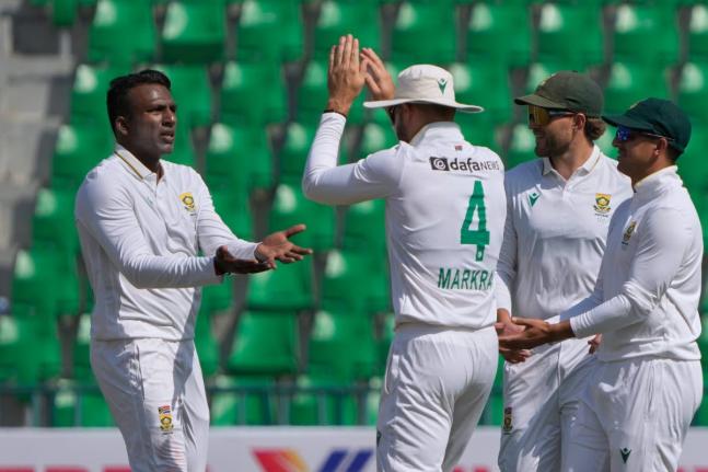 South Africa’s Senuran Muthusamy (left) celebrates with teammates after taking the wicket of Pakistan’s Mohammad Rizwan during the second day of the first Test match in Lahore, Pakistan, yesterday.