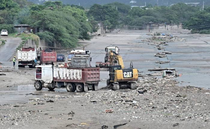 Heavy equipment and trucks are seen at Sandy Gully clearing debris and garbage ahead of Tropical Storm Melissa.
