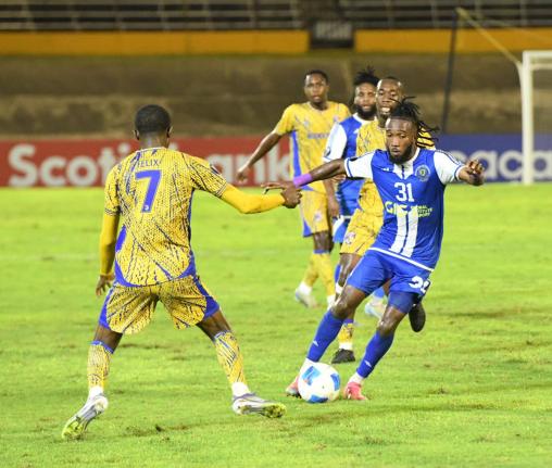 Demario Phillips (right)  of Mount Pleasant controls the ball as Jelani Felix of Defence Force FC tries to tackle during the Concacaf Caribbean Cup second leg semi-final match at the National Stadium on Wednesday night. Defence Force won 1-0.