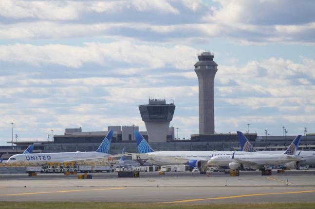 Planes are seen in front of an air traffic control tower at Newark International Airport in Newark, N.J., Thursday, November 6, 2025. (AP Photo/Seth Wenig)