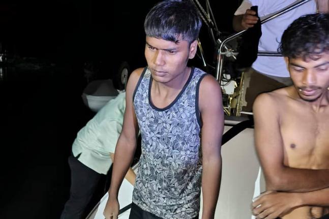 This photo released by Malaysian Maritime Enforcement Agency shows migrants handed over to authorities after they were rescued by a sailboat, in waters off northern resort island of Langkawi.