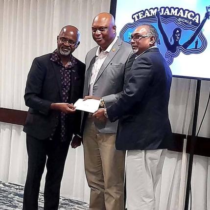 Irwine Clare Sr (left), founder and CEO of Team Jamaica Bickle, presents hurricane relief cheque to GC Foster College of Physical Education and Sport  Principal Maurice  Wilson (centre) and Board Chairman  Vishu Tolan.