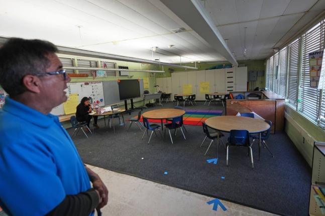 Principal Fernando Hernandez looks on in an empty classroom where a teacher is taking a lunch break at Perkins K-8 School Thursday, November 13, 2025, in San Diego. (AP Photo/Gregory Bull)