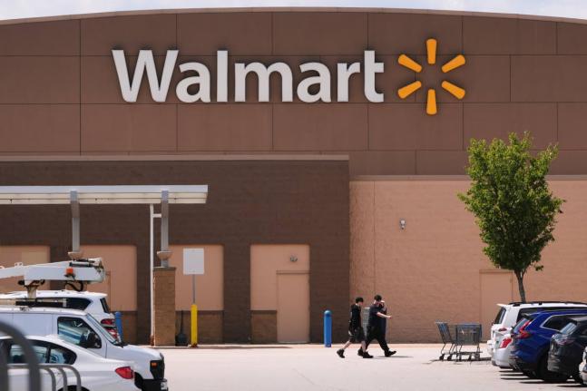 
Shoppers walk from the Walmart store on August 14, 2025 in Manchester, New Hampshire.