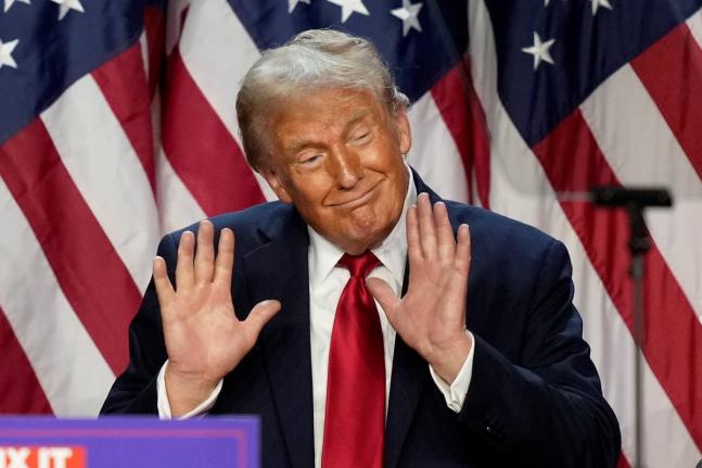 President Donald Trump showing hands at speaking engagement in 2024. 	 