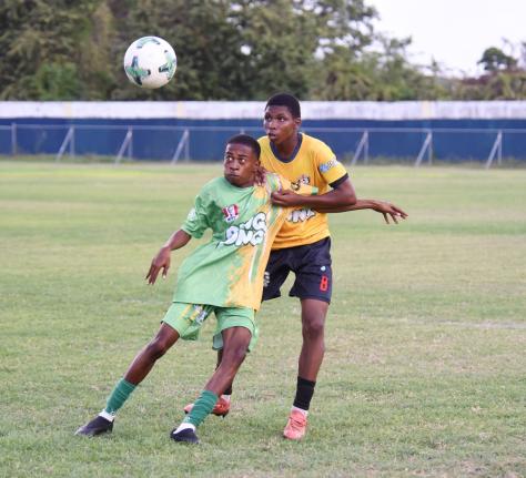 Ocho Rios High School’s Shamari Linton shields the ball from York Castle High’s Rushawn Coke (back) during their Zone K football match in the ISSA daCosta Cup competition at Drax Hall Sports Complex on Tuesday, October 7.