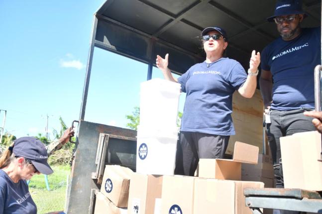 Volunteers from Canadian-based humanitarian group, GlobalMedic, demonstrate the use of the water-purification bucket while distributing hygiene kits to residents of Frome, Westmoreland, on November 27.