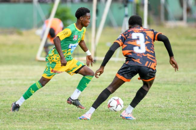 Demario Whyte (left) of Excelsior High School tries to go around Jahiem Fuller of Tivoli Gardens during an ISSA/WATA Manning Cup round-of-16 encounter at the Excelsior High School football field, yesterday. Excelsior won 3-2.