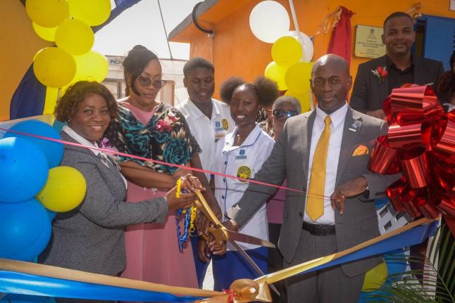 Technical support officer at the Ministry of Education, Skills, Youth and Information, Dr Nahema Daniels Heath (second left), cuts the ribbon to open a smart greenhouse at the José Martí Technical High School in St Catherine on December 5. Joining her (f