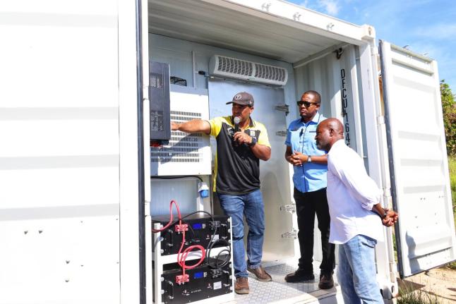 Agriculture Minister Floyd Green (centre), and acting CEO of the Rural Agricultural Development Authority, Garnet Edmondson (right), are shown features of one of the two 20-foot solar-powered cold-storage containers by RADA parish manager for St Elizabeth,