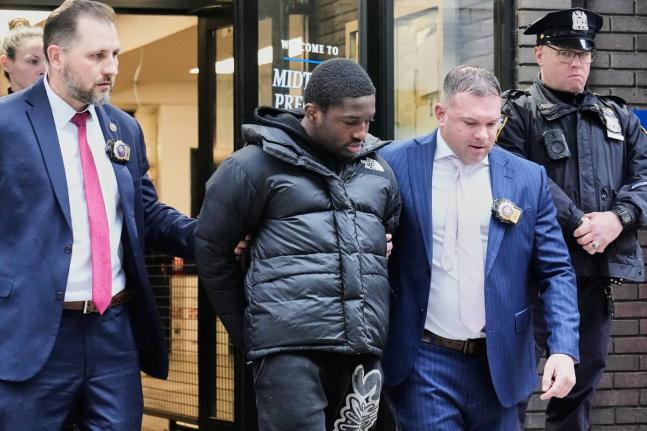 Frederick Green, 20, (second left) of The Bronx borough of New York, charged with attempted murder in the shooting of New York Jets’ player Kris Boyd, is escorted from the Midtown South Police Precinct, in New York yesterday.